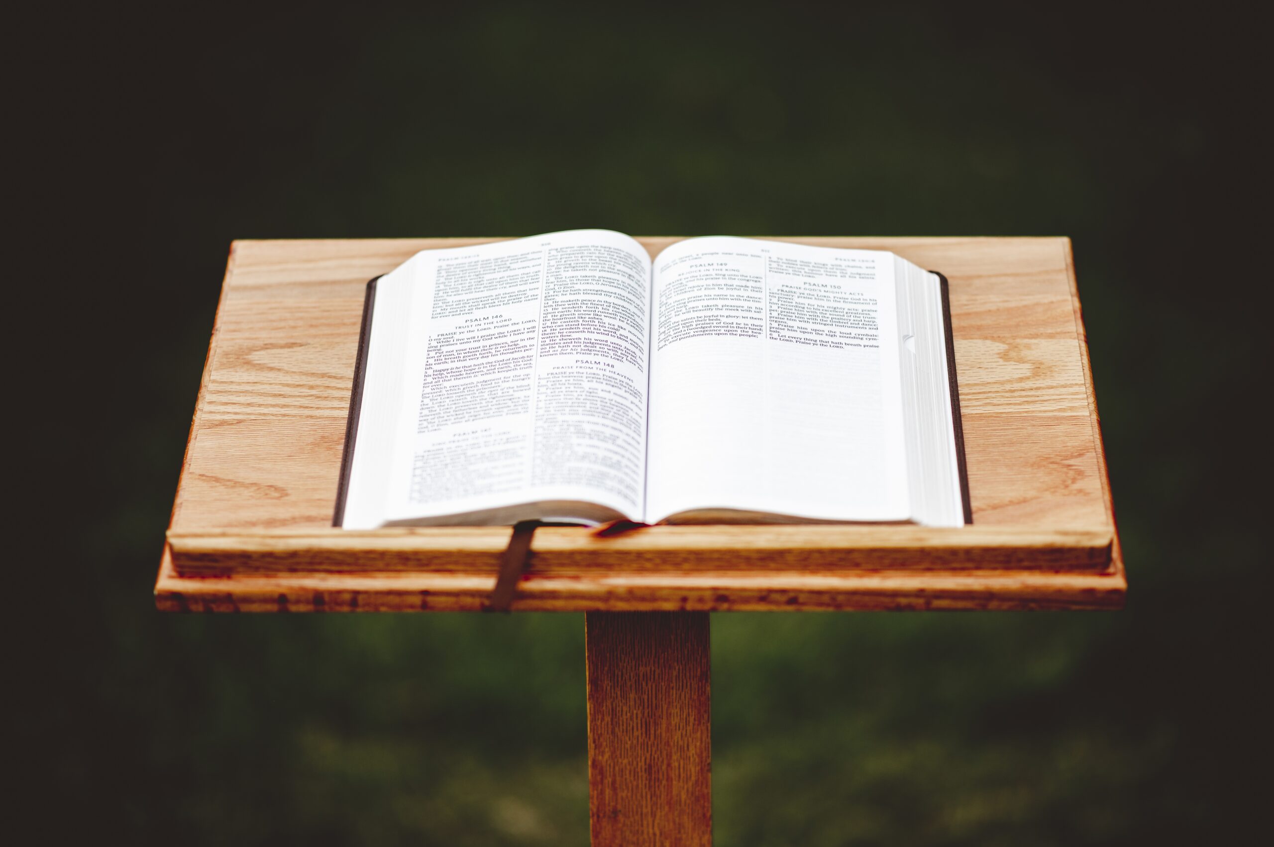 A closeup shot of a wooden speech stand with an opened book- perfect for bible, religion, oratory, lecture concepts